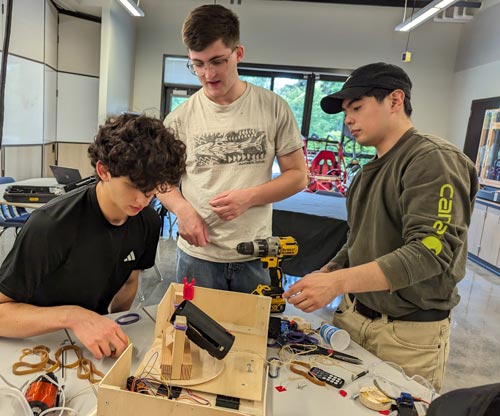 A team of Clark students assemble their project and prepare to test it in the 2024 Engineering Competition