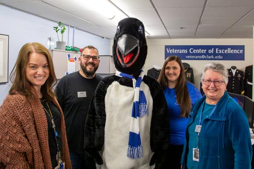 Veterans Center of Excellence staff standing with Oswald for a picture.