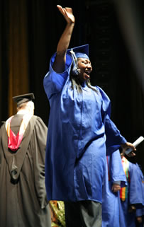 Excited Clark College graduate waves to the audience