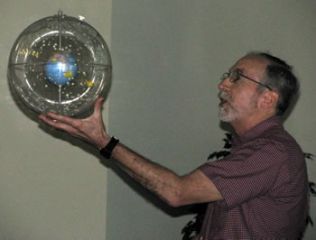 Dick Shamrell holding a globe featuring the stars